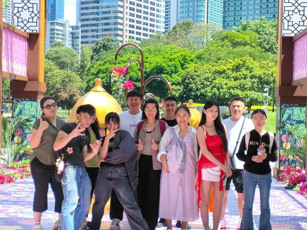 A group of students and teachers together outdoors in a Kuala Lumpur park.