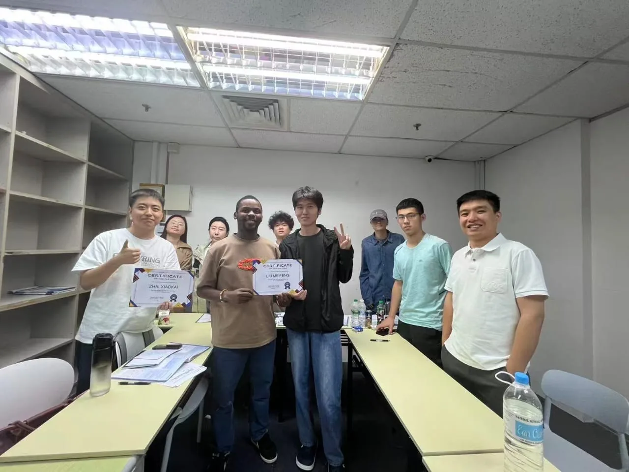 Students and teachers together holding completion certificates.